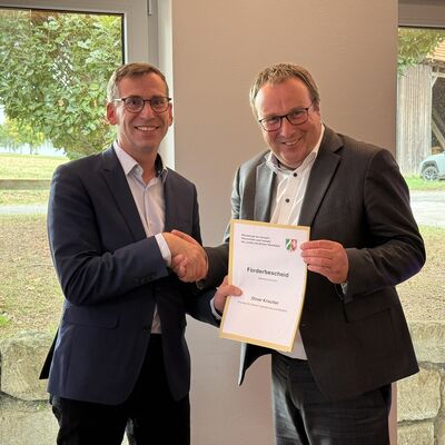 Bild vergr&ouml;&szlig;ern: NRW-Verkehrsminister Oliver Krischer �bergibt den F�rderbescheid an Warburgs B�rgermeister Tobias Scherf